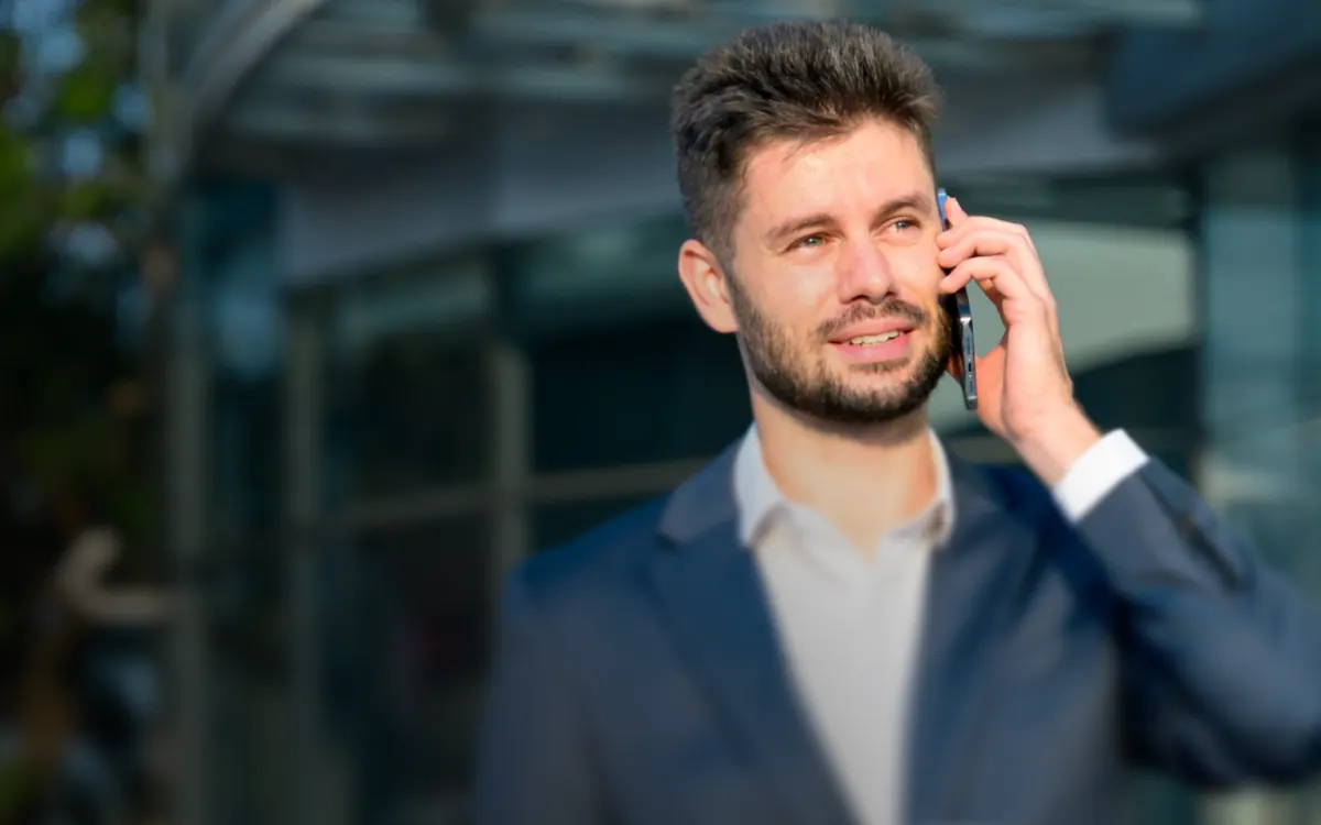 Homem falando ao celular na rua